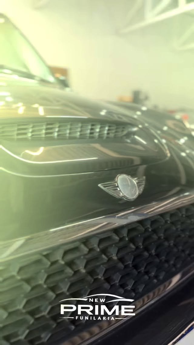 Detalhe real de frente de carro escuro polido na oficina New Prime Funilaria